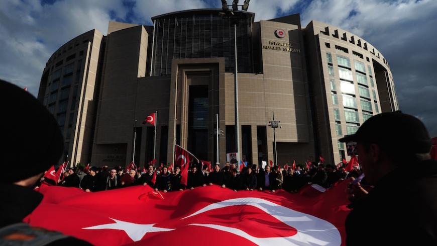 Supporters of Zaman daily newspaper wave a giant Turkish flag outside Istanbul's courthouse during a protest against the hugely controversial raids targeting Zaman newspaper and television channel linked to US-based Muslim cleric Fethullah Gulen, on December 18, 2014 in Istanbul. Twelve suspects, including the editor-in-chief of daily Zaman, Ekrem Dumanli, and the head of the Samanyolu Media Group, Hidayet Karaca, were sent to court with demands for their arrest, while probation was sought for the other fou