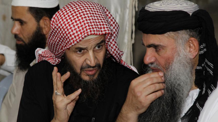 Radical Muslim cleric Abu Qatada (R) listens to Islamist scholar Sheik Abu Mohammad al Maqdisi during a celebration after his release from a prison near Amman September 24, 2014. Abu Qatada walked free from a Jordanian jail on Wednesday after being cleared of charges of conspiring in a plot to attack tourists - his second acquittal this year following a long extradition process from Britain. The state security court in the capital Amman ruled that the charges against the radical preacher - providing spiritu
