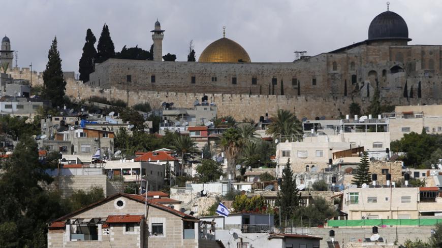 The Dome of the Rock and al-Aqsa mosque are seen in background as an Israeli flag flutters from atop a home of Jewish settlers in Silwan, a mostly Palestinian district abutting the Old City, November 3, 2014. For months, the streets of mainly Arab East Jerusalem, in the shadow of the Old City but where tourists seldom venture, have been ablaze, with daily clashes between armed Israeli police and Palestinians throwing rocks and Molotov cocktails.The roots of the unrest are many: from the killing in July of a