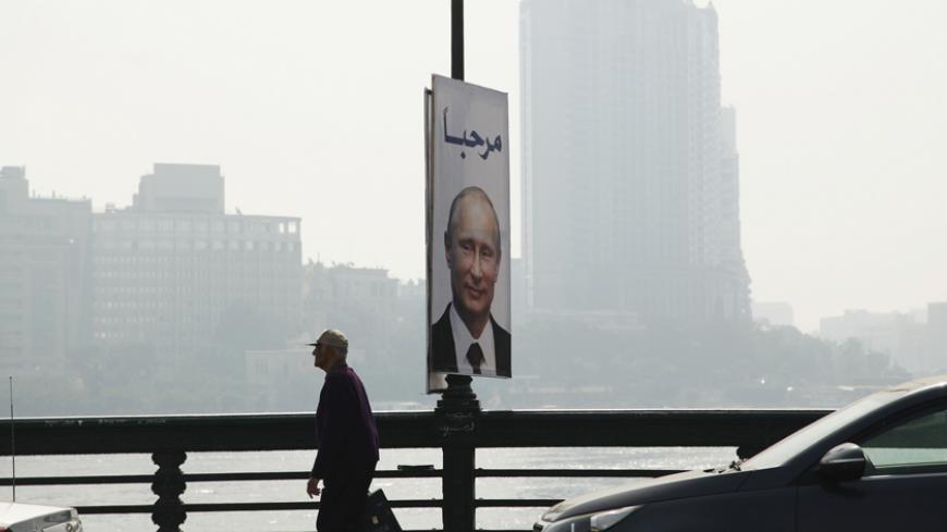 A man walks past a banner with a picture of Russian President Vladimir Putin along a bridge, in central Cairo February 9, 2015. Putin is due to arrive on Monday on his first visit to Egypt in ten years. The banner reads "Welcome" REUTERS/Asmaa Waguih(EGYPT - Tags: POLITICS) - RTR4OTYE