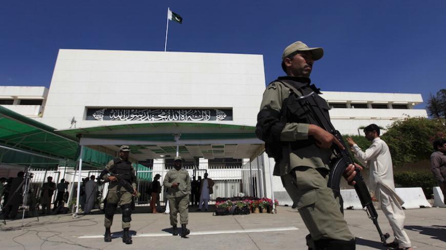 Paramilitary soldiers walk past the Parliament building during a joint sitting of the parliament in Islamabad April 10, 2015. Pakistan's parliament adopted a draft resolution on Yemen on Friday urging Pakistan to stay neutral in the conflict, as expected, expressing support for Saudi Arabia and calling on all factions to resolve their differences peacefully.  REUTERS/Faisal Mahmood - RTR4WS99