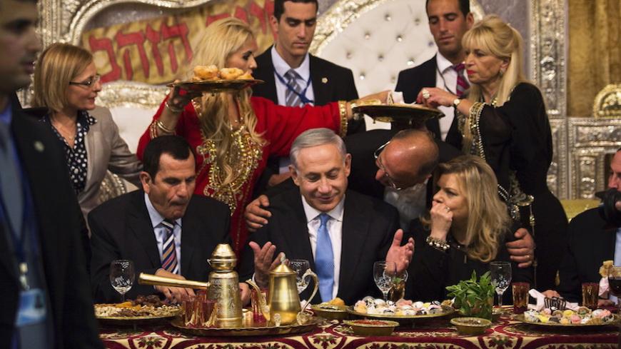 Israeli Prime Minister Benjamin Netanyahu (C) and his wife Sara (2nd R) attend the Mimona ceremony at the Israeli town of Or Akiva near Caesarea April 11, 2015. Mimona is traditionally celebrated by Jews from North Africa at the end of the Passover holidays. REUTERS/Amir Cohen - RTR4WY31