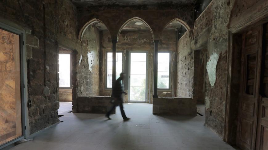 A man passes through a damaged room in the historic "Barakat" building known as "The Yellow House" on the former green line in Beirut, April 15, 2015. The Yellow House or Beit Beirut is one of the buildings that have witnessed the Lebanese civil war. Renovation of the building that was extremely damaged during the war is taking place to turn it into a museum and a cultural meeting place through a 2008 agreement between Beirut and Paris to preserve the history of the city, local media reported. Picture taken