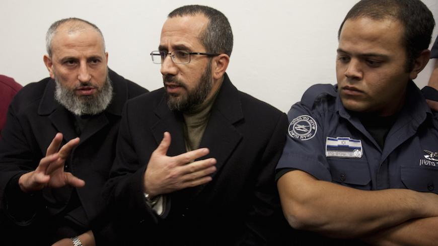 Palestinian Senior Hamas legislator Mohammed Totah (L) and former Palestinian minister for Jerusalem affairs Khaled Abu Arafeh (C), are seen at the Magistrate's Court for their hearing in Jerusalem on January 24, 2012. The men were arrested the day before from the offices of the International Committee of the Red Cross in east Jerusalem where they were taking refuge to avoid deportation from Jerusalem to the West Bank. Over 20 of Hamas's 74 MPs in the 132-member PLC are currently being held by Israel, with 