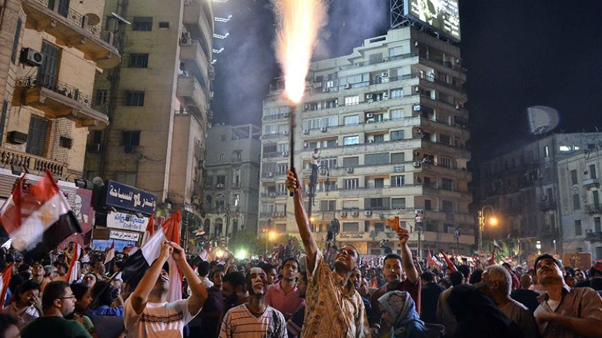 An Egyptian protester lights up a flare as hundreds of thousands of Egyptian demonstrators gather in Cairo's landmark Tahrir square during a protest calling for the ouster of President Mohamed Morsi on July 1, 2013. Egypt's armed forces warned that it will intervene if the people's demands are not met within 48 hours, after millions took to the streets to demand the president's resignation.    AFP PHOTO/MOHAMED EL-SHAHED        (Photo credit should read MOHAMED EL-SHAHED/AFP/Getty Images)