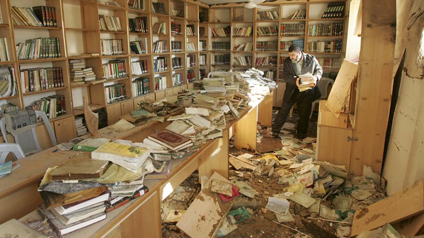 A Palestinian man inspects the damage to a library inside al-Eslah mosque after local witnesses said it was hit by an Israeli airstrike in Gaza November 18, 2006.  REUTERS/Mohammed Salem (GAZA) - RTR1JGJZ