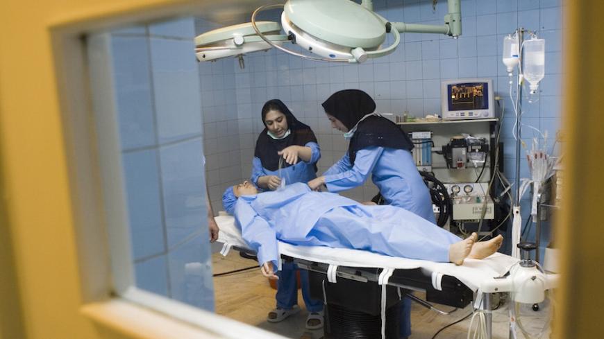 Nurses prepare Iranian woman Arezoo Abassi in the operating room as she gets ready for a surgery on her nose at a surgical clinic in Tehran May 29, 2007.  REUTERS/Caren Firouz  (IRAN) - RTR1Q8AF