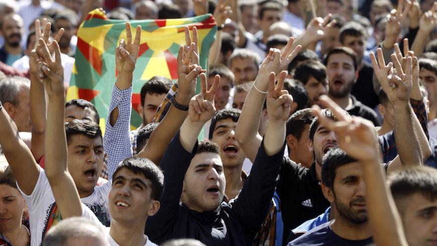 Kurdish demonstrators gesture as Selahattin Demirtas, co-chair of the HDP, Turkey's leading Kurdish party, addresses a crowd in Diyarbakir October 9, 2014. A three-week battle for the Syrian border town of Kobani has also led to the worst streets clashes in years between police and Kurdish protesters across the frontier in southeast Turkey. In Diyarbakir, Turkey's biggest Kurdish city, five people were killed in clashes on Monday and Tuesday between Islamist groups and PKK supporters, a senior police office