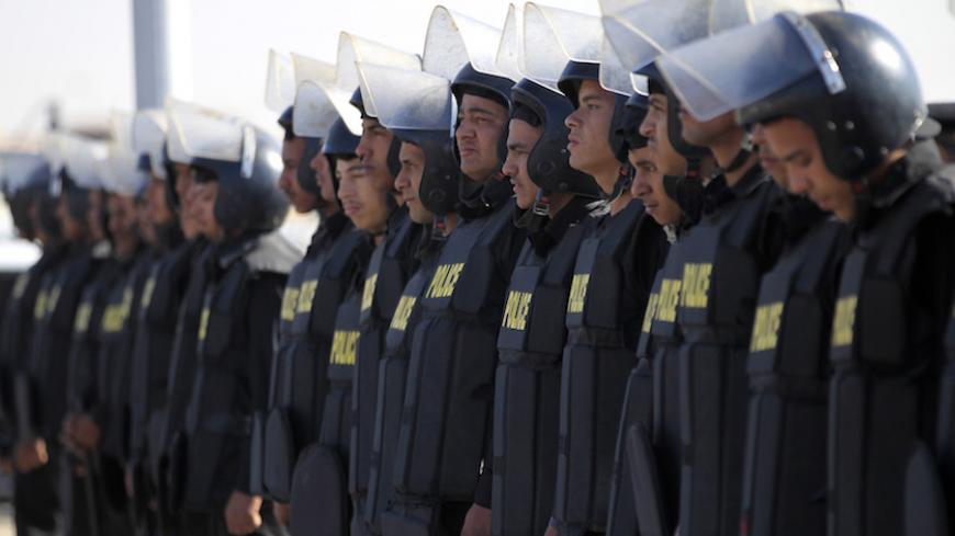 Police and security forces stand guard outside a police academy where the trial of ormer Egyptian President Hosni Mubarak is held on the outskirts of Cairo November 29, 2014. An Egyptian court on Saturday dropped its case against ousted president Hosni Mubarak on charges of ordering the killing of protesters during the 2011 revolt that removed him from power. The court also cleared Mubarak and a former oil minister of graft charges related to gas exports to Israel.  REUTERS/Mohamed Abd El Ghany (EGYPT - Tag