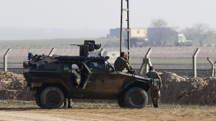 Turkish soldiers monitor the border line as they stand guard near the Akcakale border crossing in Sanliurfa province, southeastern Turkey, where Islamic State militants control the Syrian side of the gate, January 29, 2015. An audio message purportedly from a Japanese journalist being held by Islamic State militants said a Jordanian air force pilot also captured by the group would be killed unless an Iraqi female prisoner in Jordan was released by sunset on Thursday. The message appeared to postpone a previ