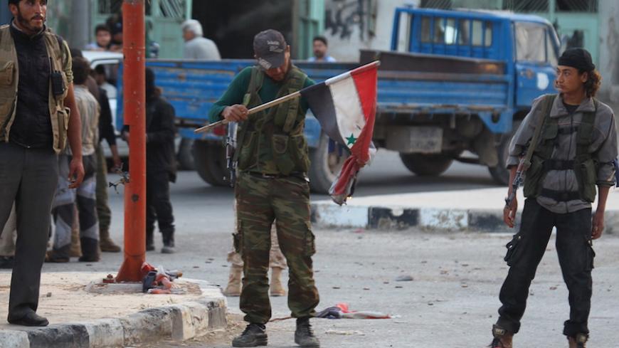 A member of al Qaeda's Nusra Front burn a Syrian national flag in the town of the northwestern city of Ariha, after a coalition of insurgent groups seized the area in Idlib province May 29, 2015. The Syrian army has pulled back from the northwestern city of Ariha after a coalition of insurgent groups seized the last city in Idlib province in northwestern Syria near the Turkish border that was still held by the government. A coalition of rebel groups called Jaish al Fateh, or Conquest Army, said it had taken