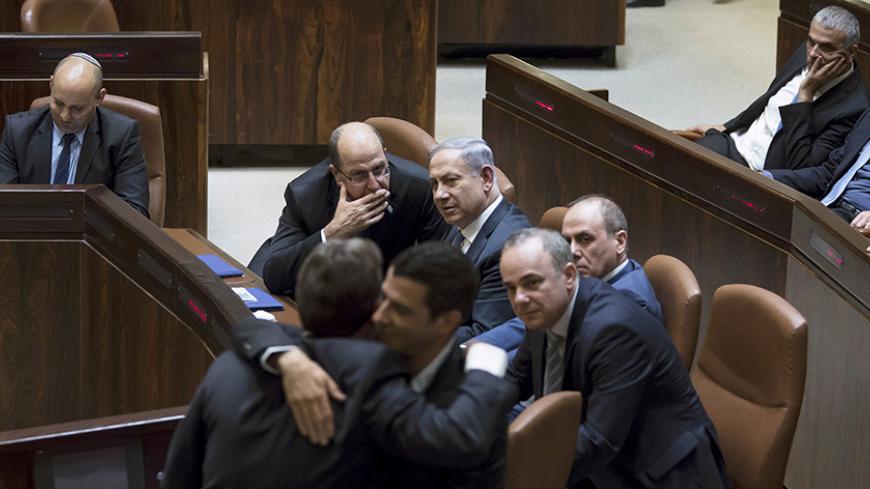Israeli Prime Minister Benjamin Netanyahu (C) sits next to his Defense Minister Moshe Ya'alon (L) during a swearing-in ceremony at the Knesset, the Israeli parliament, in Jerusalem May 14, 2015. Netanyahu's new rightist coalition government, hobbled from the outset by its razor-thin parliamentary majority, was sworn in late on Thursday amid wrangling within his Likud party over cabinet posts. Picture taken May 14, 2015. REUETRS/Jim Hollander/Pool - RTX1D2SJ