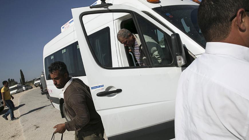 Palestinian labourers with permits to work in Israel step off a minibus as they return to the West Bank at Israel's Eyal checkpoint near the West Bank town of Qalqilya May 20, 2015. Prime Minister Benjamin Netanyahu suspended on Wednesday new bus travel and checkpoint regulations for Palestinian labourers only hours after they were imposed to an outcry by critics accusing Israel of racial segregation. REUTERS/Baz Ratner - RTX1DTRU