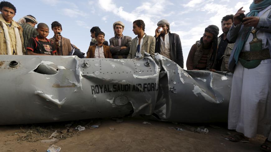 People stand by part of a Saudi fighter jet found in Bani Harith district north of Yemen's capital Sanaa May 24, 2015. Local media said that the Houthi rebels brought down a Saudi F-16 fighter jet north of Sanaa early on Sunday. REUTERS/Khaled Abdullah - RTX1EAP8