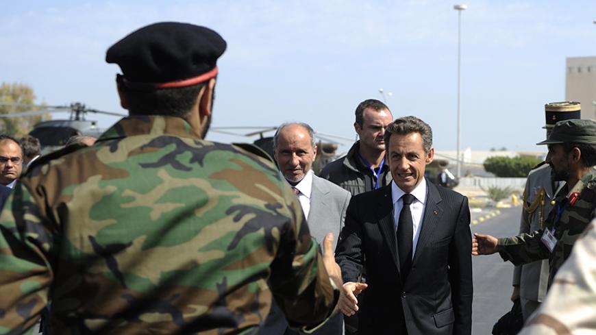 A pro-National Transitional Council (NTC) combatant greets France's President Nicolas Sarkozy (R) and National Transitional Council (NTC) head Mustafa Abdul Jalil (C) as they arrive at the Tripoli Medical Center September 15, 2011. President Sarkozy and Britain's Prime Minister David Cameron (not pictured) travel to Libya, making stops in Tripoli and Benghazi, the first visit by foreign leaders since the toppling of the former regime.   REUTERS/Eric Feferberg/Pool    (LIBYA - Tags: POLITICS CIVIL UNREST) - 