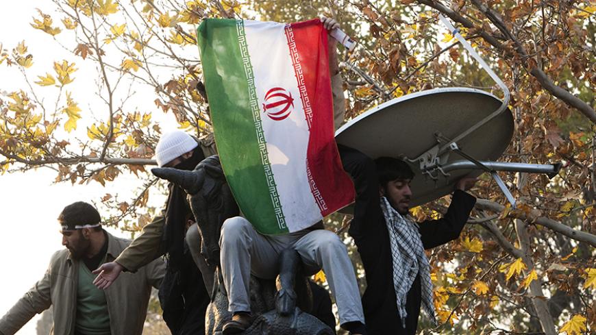 EDITORS' NOTE: Reuters and other foreign media are subject to Iranian restrictions on leaving the office to report, film or take pictures in Tehran.
Iranian protesters remove a satellite dish from a building near the gate of the British Embassy in Tehran November 29, 2011. Dozens of young Iranian men entered buildings inside the British embassy compound in Tehran on Tuesday, throwing rocks, petrol bombs and burning documents looted from offices, Iranian news agencies reported. REUTERS/Raheb Homavandi  (IRAN