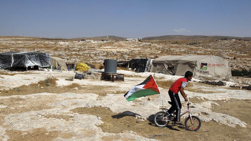 A Palestinian boy rides a bicycle past tents in the West Bank village of Susiya June 24, 2012. Susiya the Israeli settlement enjoys well-watered lawns, humming electricity, and the protection of a mighty state. One rocky hill away, Susiya the Palestinian village is parched and doomed. Picture taken June 24, 2012. To match Feature ISRAEL-PALESTINIANS/DEMOLITION 
  REUTERS/Baz Ratner (WEST BANK - Tags: POLITICS) - RTR347HR