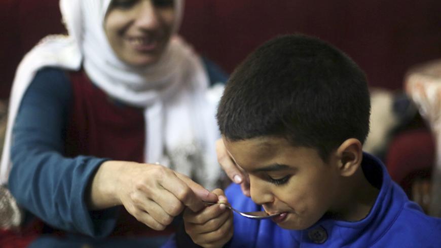 Sherien Fathy, a blind 32-year-old mother of two, feeds her son Yehia at her home in Cairo March 5, 2014. Sherien, a graduate of the College of Arts? Arabic department who works as a specialist manager at the General Petroleum Corporation, hopes the government will do more to help disabled people to find jobs and contribute to the economy. Sherien is married to lawyer Khaled Hanafy, who is also blind. On March 8 activists around the globe celebrate International Women's Day, which dates back to the beginnin