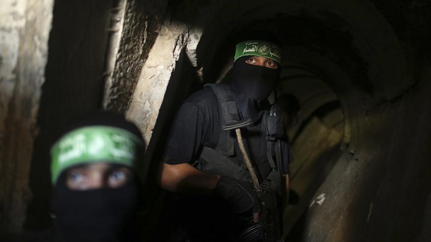 Palestinian fighters from the Izz el-Deen al-Qassam Brigades, the armed wing of the Hamas movement, are seen inside an underground tunnel in Gaza August 18, 2014. A rare tour that Hamas granted to a Reuters reporter, photographer and cameraman appeared to be an attempt to dispute Israel's claim that it had demolished all of the Islamist group's border infiltration tunnels in the Gaza war. Picture taken August 18, 2014. REUTERS/Mohammed Salem (GAZA - Tags: POLITICS CONFLICT TPX IMAGES OF THE DAY) - RTR42YJR