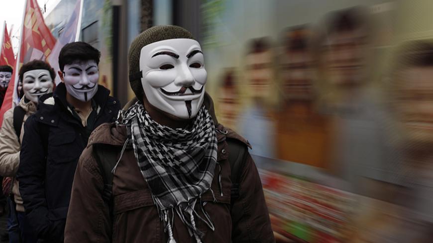 High school students wearing Guy Fawkes masks take part in a protest against the education policies of the ruling AK Party as a tram drives by in Istanbul February 13, 2015. Education is the latest flashpoint between the administration of President Tayyip Erdogan, and secularist Turks who accuse him of overseeing creeping 'Islamisation' in the NATO member state. Parts of some regular schools have been requisitioned to create more places for students in "Imam Hatip" religious schools championed by Erdogan, w