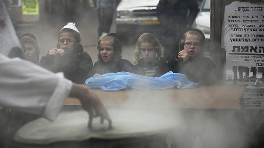 Ultra-Orthodox Jewish youths watch as a man dips cooking utensils in boiling water to remove remains of leaven in preparation for the Jewish holiday of Passover, in Jerusalem's Mea Shearim neighbourhood April 1, 2015. Passover, which starts on Friday, commemorates the flight of Jews from ancient Egypt, as described in the Exodus chapter of the Bible. According to the account, the Jews did not have time to prepare leavened bread before fleeing to the promised land. REUTERS/Baz Ratner - RTR4VREJ