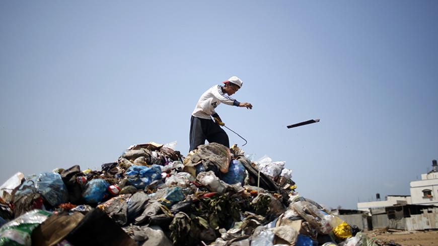 A Palestinian sifts through garbage for salvageable items at a local dump site, in the east of Gaza City September 2, 2013.  REUTERS/Mohammed Salem (GAZA - Tags: ENVIRONMENT SOCIETY) - RTX134M2
