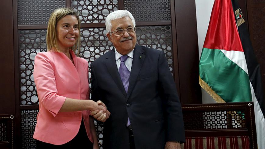 European Union foreign policy chief Federica Mogherini (L) shakes hands with Palestinian President Mahmoud Abbas during their meeting in the West Bank city of Ramallah May 20, 2015. REUTERS/Mohamad Torokman - RTX1DRH1