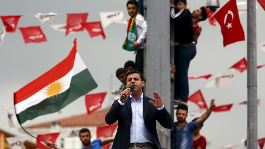 Selahattin Demirtas, co-chairman of the pro-Kurdish Peoples' Democratic Party (HDP), speaks as his supporters wave Kurdish (L) and Turkish national (R) flags in the background, during an election rally for Turkey's June 7 parliamentary election, in Istanbul, Turkey, June 6, 2015. Turkey's Kurdish-rooted opposition party, which could scupper Tayyip Erdogan's ambitions for sweeping new powers, accused the President on Saturday of a lack of respect for supporters killed in a bomb attack in an election rally an