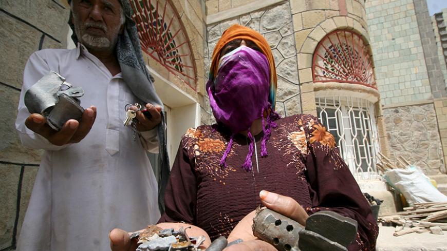 People display fragment of shells they collected from their house amid  clashes between members of the anti-Houthi Popular Resistance Committees and Houthi fighters in Yemen's southwestern city of Taiz, June 15, 2015. REUTERS/Stringer - RTX1GJW9