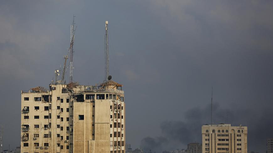 Veiw of the media complex (L) that houses the offices of Hamas-run Al Aqsa television and radio after it was targeted in an Israeli strike in central Gaza City early on July 29, 2014.  Israeli aircraft, tanks and navy gunboats pounded symbols of Hamas control in Gaza City in the heaviest night of bombardment in three weeks of Israel-Hamas fighting.  AFP PHOTO / MOHAMMED ABED        (Photo credit should read MOHAMMED ABED/AFP/Getty Images)