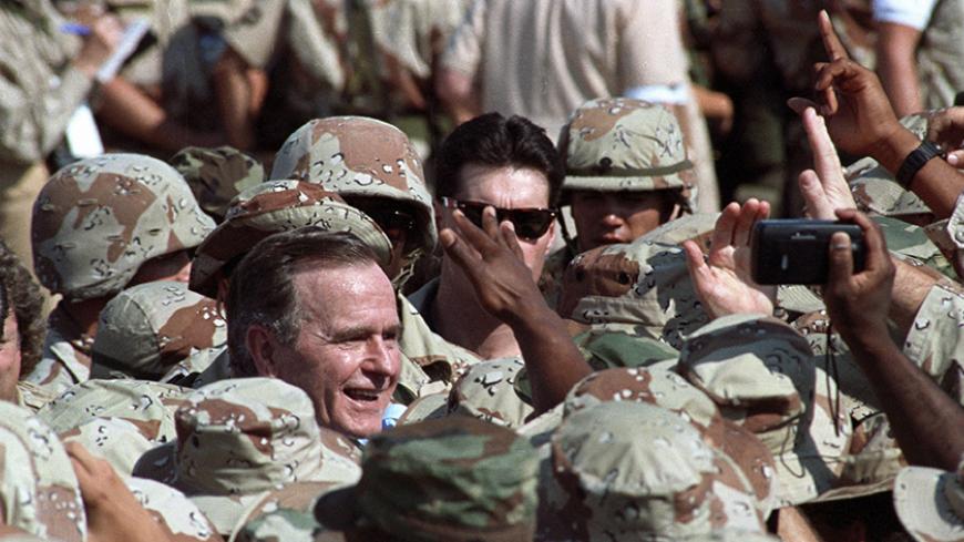 President George H.W. Bush is surrounded by a sea of U.S. military personnel as he greets troops following an arrival ceremony in the eastern Saudi Arabian city of Dhahran November 22, 1990. Bush celebrates Thanksgiving Day with U.S. troops from all branches of the military deployed here after the Iraqi invasion of Kuwait.   Reuters/Terry Bochatey ( SAUDI ARABIA - Tags: POLITICS CIVIL UNREST) BEST QUALITY AVAILABLE - RTR2ZNUI