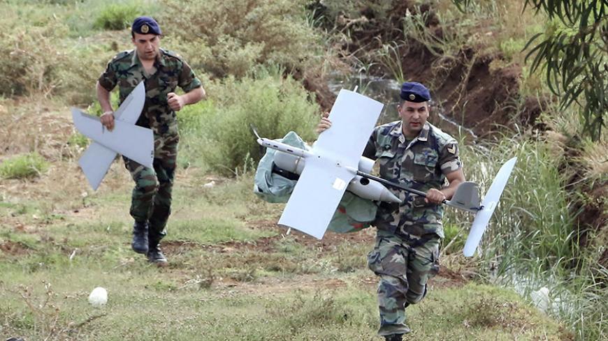 Lebanese Army soldiers carry parts of an Israeli drone in the Marjeyoun countryside, south Lebanon September 20, 2014. The Lebanese Army found the MK drone that fell in the Marjeyoun countryside near the Lebanese-Israeli border, the National News Agency (NNA) reported. The Israel Defence Forces confirmed that the unmanned aerial vehicle was from Israel, according to Israeli media.   REUTERS/Karamallha Daher (LEBANON - Tags: POLITICS MILITARY TPX IMAGES OF THE DAY) - RTR4711K