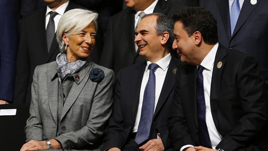 International Monetary Fund (IMF) Managing Director Christine Lagarde (L) chats with Turkey's Deputy Prime Minister Ali Babacan (R) and Turkish Central Bank Governor Erdem Basci (C) during a family photo session at the G20 finance ministers and central bank governors meeting in Istanbul February 10, 2015. The United States urged a meeting of the Group of 20 leading economies not to resort to currency devaluations to boost exports, while a draft communique gave a gloomy assessment on Tuesday of the outlook f