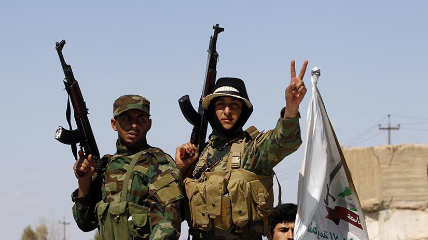 Sunni fighters who have joined Shi'ite militia groups known collectively as Hashid Shaabi (Popular Mobilization), who are allied with Iraqi forces against the Islamic State, gesture with their weapons in al-Alam Salahuddin province March 17, 2015. Iraq paused its Tikrit offensive on Monday and officials called for more air strikes against Islamic State militants, while an officer said Kurdish forces sustained two more chlorine gas attacks by insurgents.  REUTERS/Thaier Al-Sudani (IRAQ - Tags: POLITICS CIVIL