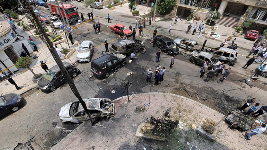 A view shows burnt cars at the site of a car bomb attacked the convoy of Egyptian public prosecutor Hisham Barakat near his house at Heliopolis district in Cairo, Egypt, June 29, 2015. Barakat was injured when a car bomb struck his convoy as it was leaving his home in Cairo on Monday, in a high-profile attack against the judiciary, security and judicial sources said. REUTERS/Mohamed Abd El Ghany - RTX1I937