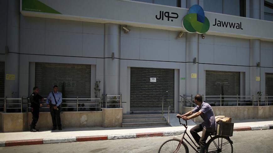 Palestinian policemen loyal to Hamas stand guard outside closed Jawwal company headquarters in Gaza City June 30, 2015. The Hamas-appointed attorney general in Gaza shut down the offices of the territory's only mobile-phone provider on Tuesday, saying the company, Jawwal, had not paid its taxes. Jawwal is a subsidiary of the Palestine Telecommunications Co. (PalTel), the largest listed company in the Palestinian territories. It is the sole provider of mobile phone services in Gaza, with around 1.3 million c