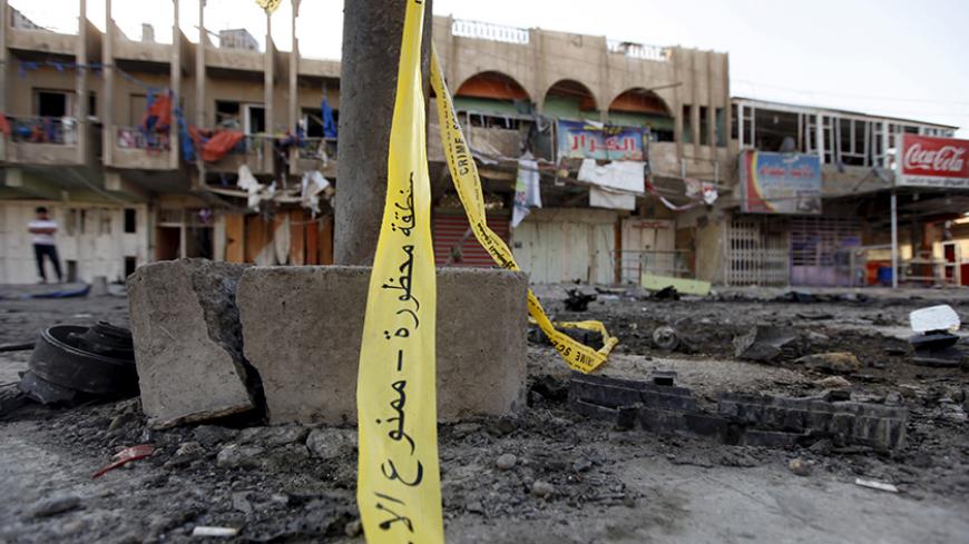 The site of a bomb attack is seen in Baghdad July 23, 2015. A car bomb exploded in a crowded marketplace in a mainly Shi'ite Muslim district of the Iraqi capital on Wednesday, killing at least 20 people, police and medical sources said.  REUTERS/Ahmed Saad - RTX1LFX6