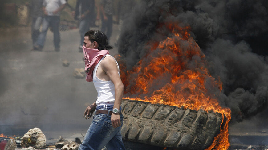 Pro-government loyalists set barricades and burn tyres on the main highway leading to southern Lebanon in Jiyeh area, south of Beirut, May 8, 2008. Pro-government activists blocked a highway linking Beirut to the mainly Shi'ite south with burning tyres and mounds of earth and set up a barricade on the main road to the border with Syria, a strong backer of Hezbollah.   REUTERS/Ali Hashisho (LEBANON) - RTX5HB9