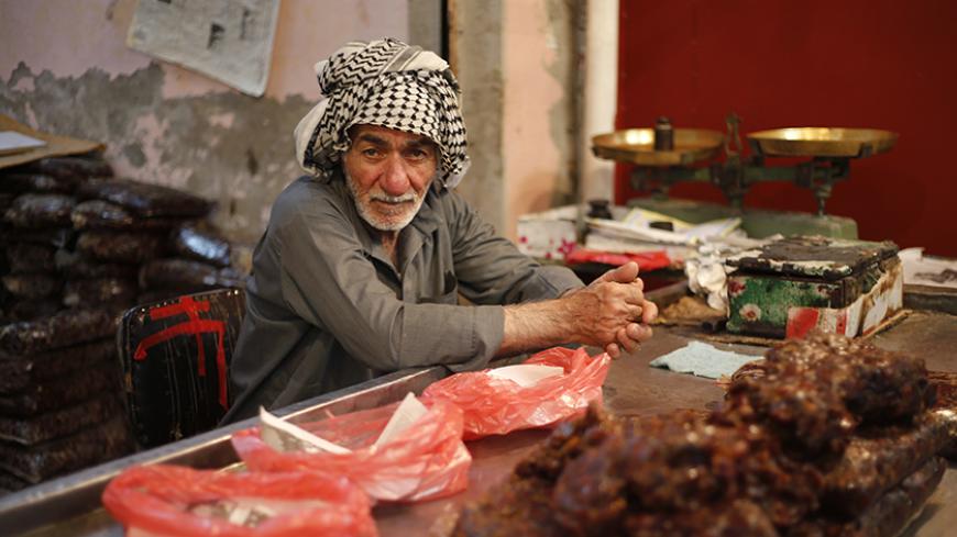 An Iraqi Shi'ite man sells dates in his shop at the market in Sadr City in Baghdad April 29, 2014. Iraq is now gripped by its worst violence since the heights of its 2005-2008 sectarian war, and Sunni Islamist insurgents who target Shi'ites have been regaining ground in the country over the past year. But despite the instability, daily life continues in poor Shi'ite neighbourhoods of Baghdad such as Al-Fdhiliya and Sadr City - a sprawling slum marred by poor infrastructure and overcrowding.  REUTERS/Ahmed J
