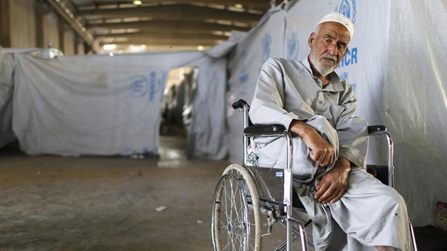 A displaced Iraqi man, who fled from Islamic State violence in Mosul, sits in a wheelchair at Baherka refugee camp in Erbil September 19, 2014. REUTERS/Ahmed Jadallah (IRAQ - Tags: CIVIL UNREST CONFLICT SOCIETY) - RTR46YAX