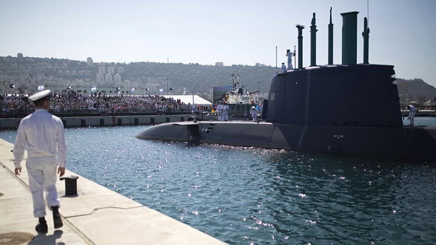 An Israeli naval officer walks on the pier at a naval base in the northern city of Haifa as INS Tanin, a Dolphin AIP class submarine, docks after its arrival in Israel, September 23, 2014. Tanin is the fourth submarine Israel has acquired, and is the first of three German-built Dolphin AIP class vessels ordered by Israel, an Israeli Defence Forces spokesperson said on Tuesday. REUTERS/Amir Cohen (ISRAEL - Tags: MILITARY) - RTR47EHT