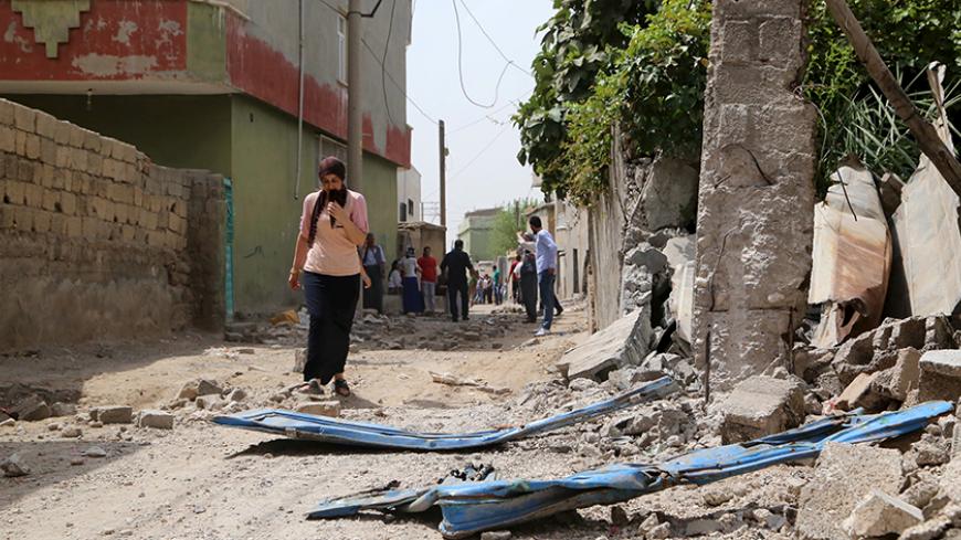 A woman walks along a street in the southeastern Turkish town of Silopi in Sirnak province, near the Turkish-Iraqi border crossing of Habur, Turkey, August 7, 2015. Five people were killed in eastern Turkey on Friday in a series of clashes between security forces and Kurdish militants, part of a surge in violence that has put further strain on a fragile peace process between Ankara and the rebels. Three people were killed and seven wounded during clashes between police and militants of the Kurdistan Workers