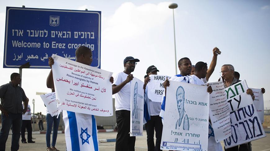 Demonstrators hold placards during aprotest calling for the release of Avraham Mengisto at the Erez Crossing in southern Israel, near the Gaza Strip August 27, 2015. Two Israeli citizens, one of them Mengisto, are being held by Hamas in the Gaza Strip, Prime Minister Benjamin Netanyahu said last month, a situation that could lead to demands for a prisoner exchange between Israel and the Islamist militant group. Hamas, the Palestinian enclave's dominant faction, declined to confirm or deny it had the captive