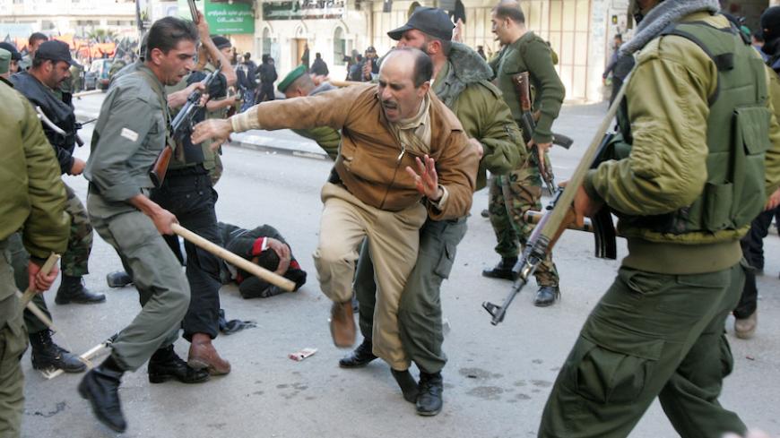 Members of the Palestinian security forces scuffle with protesters during an anti-Annapolis rally in the West Bank city of Hebron November 27, 2007. A Palestinian demonstrator was killed on Tuesday during a West Bank protest against the Annapolis peace conference that drew fire from Palestinian security forces, local medics said. Medical workers said the 35-year-old killed in Hebron had been shot in the chest and that 15 other protesters were injured during clashes with security forces loyal to President Ma