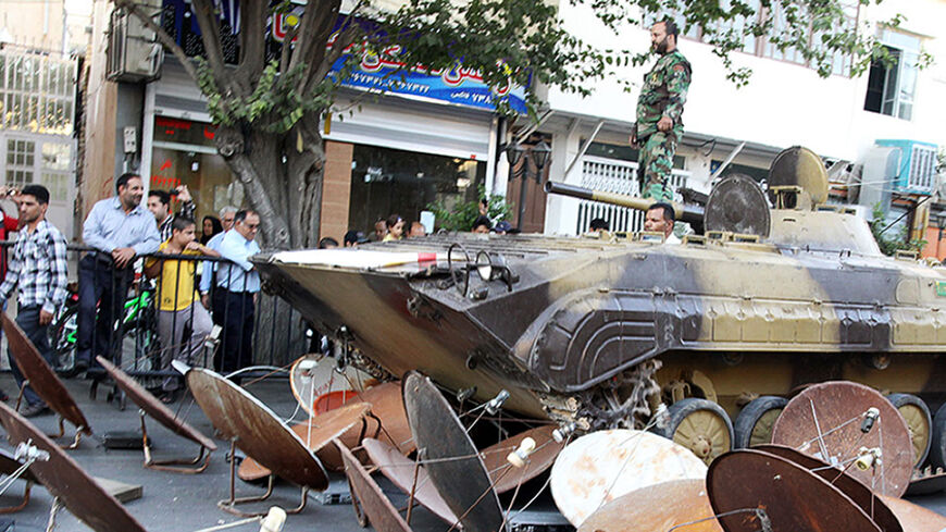 A picture taken on September 28, 2013 and obtained from Iran's ISNA news agency shows Iranian soldiers destroying satellite dishes with an army tank in a street of the southwestern city of Shiraz. The Iranian authorities carry out regular crackdowns to seize satellite dishes, removing them from rooftops, and issue warnings against their use. AFP PHOTO/ ISNA/MOHSEN TAVARO        (Photo credit should read MOHSEN TAVARO/AFP/Getty Images)