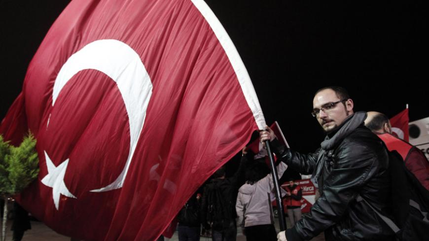 A pro-secular demonstrator holds a Turkish flag as he waits for the release of former army chief Ilker Basbug outside the Silivri prison complex near Istanbul March 7, 2014.  A Turkish court ordered the release of former general Ilker Basbug from a life sentence on Friday, adding to uncertainty over the fate of court cases trying coup plots against Prime Minister Tayyip Erdogan. The decision followed a constitutional court ruling on Thursday that Basbug's incarceration for his alleged role in the 'Ergenekon
