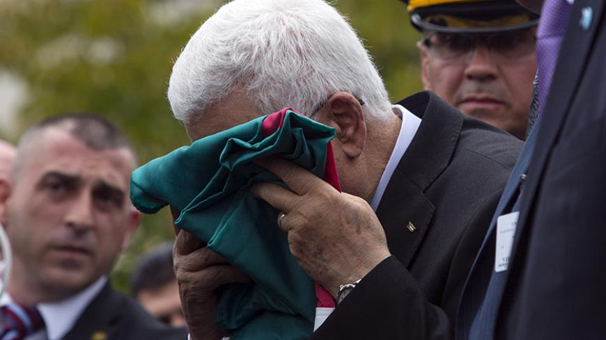 Palestinian President Mahmoud Abbas kisses a Palestinian flag before raising it during United Nations General Assembly at the United Nations in Manhattan, New York September 30, 2015. Even though Palestine is not a member of the United Nations, the General Assembly adopted a Palestinian-drafted resolution that permits non-member observer states to fly their flags alongside those of full member states. REUTERS/Andrew Kelly  TPX IMAGES OF THE DAY   - RTS2H7E