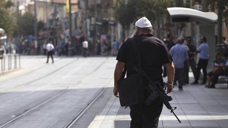 An armed man walks in the centre of Jerusalem October 19, 2015. A surge in Palestinian attacks in Israel is raising concerns that the weakening economy could eventually be pushed into recession. REUTERS/Ronen Zvulun - RTS538B