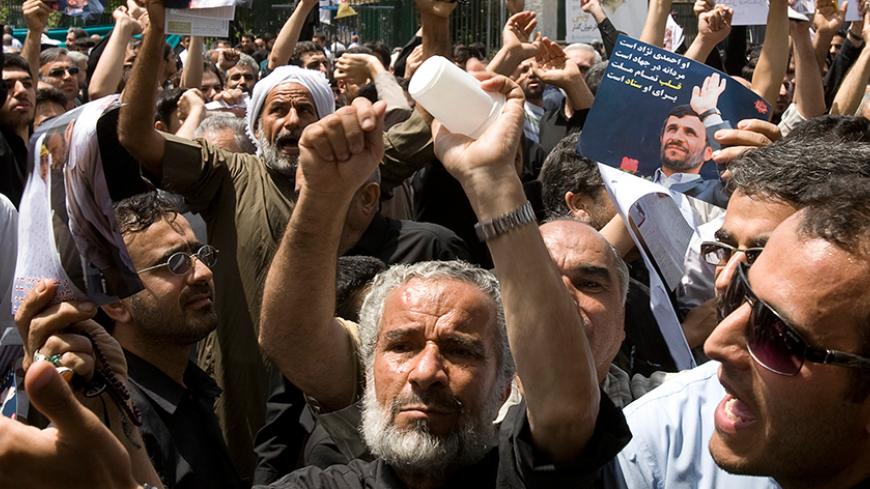 Supporters of Iranian President Mahmoud Ahmadinejad shout slogans against presidential candidate Mir Hossein Mousavi, after Friday prayers in Tehran May 29, 2009. Iranians vote on June 12 in an election that pits hardline President Ahmadinejad against two moderate challengers and one fellow conservative.    REUTERS/Raheb Homavandi (IRAN POLITICS ELECTIONS) - RTXOX0Y
