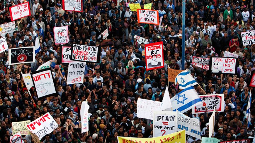 Jews who migrated from Ethiopia, their descendants and other supporters take part in a protest against discrimination of Ethiopian Jews in the southern town of Kiryat Malachi January 10, 2012. The large placard (front) in Hebrew reads, " Enough for racism".  REUTERS/Amir Cohen (ISRAEL - Tags: POLITICS CIVIL UNREST) - RTR2W3Z3
